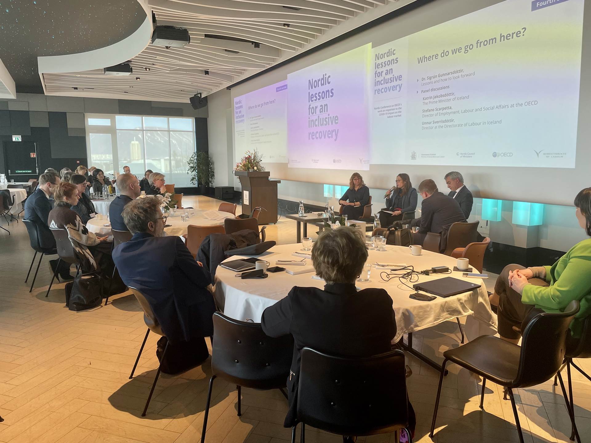 Katrín Jakobsdóttir, forsætisráðherra, Unnur Sverrisdóttir, forstjóri Vinnumálastofnunar og Stefano Scarpetta, framkvæmdastjóri hjá OECD, í pallborðsumræðum með Hugin Þór Grétarssyni, pallborðsstjóra og stjórnarformanni Vinnumálastofnunar.  - mynd