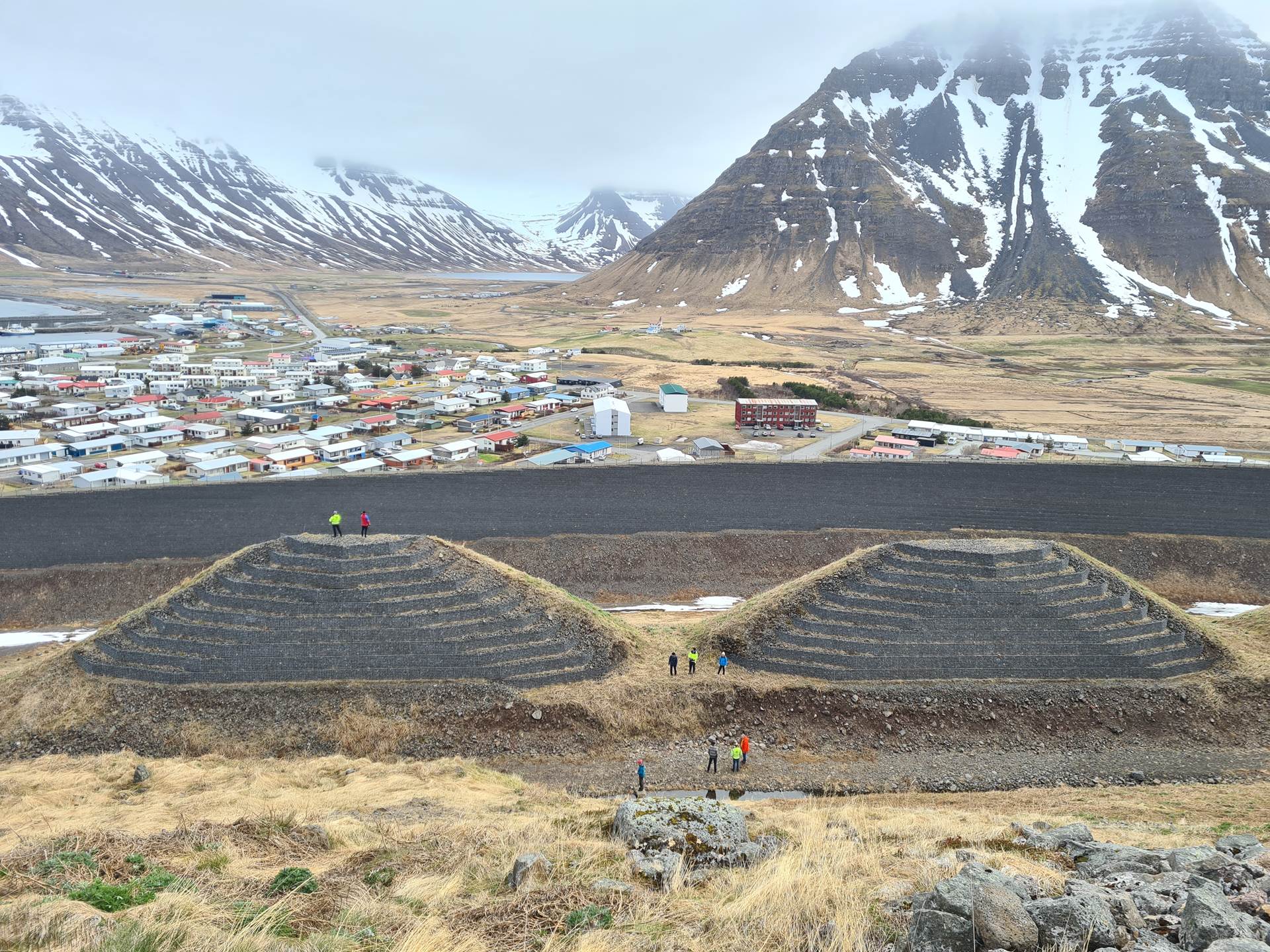 Brattar varnarkeilur ofan við háan, brattan þvergarð, ofan byggðar í Bolungarvík. Ljósmynd: KMH, 23. maí 2024. - mynd