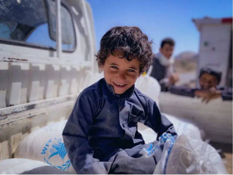 Omar, fjögurra ára, situr á hveitsekkjum WFP í Khawlan i Jemen. Mynd: WFP/Mohammed Awadh - mynd
