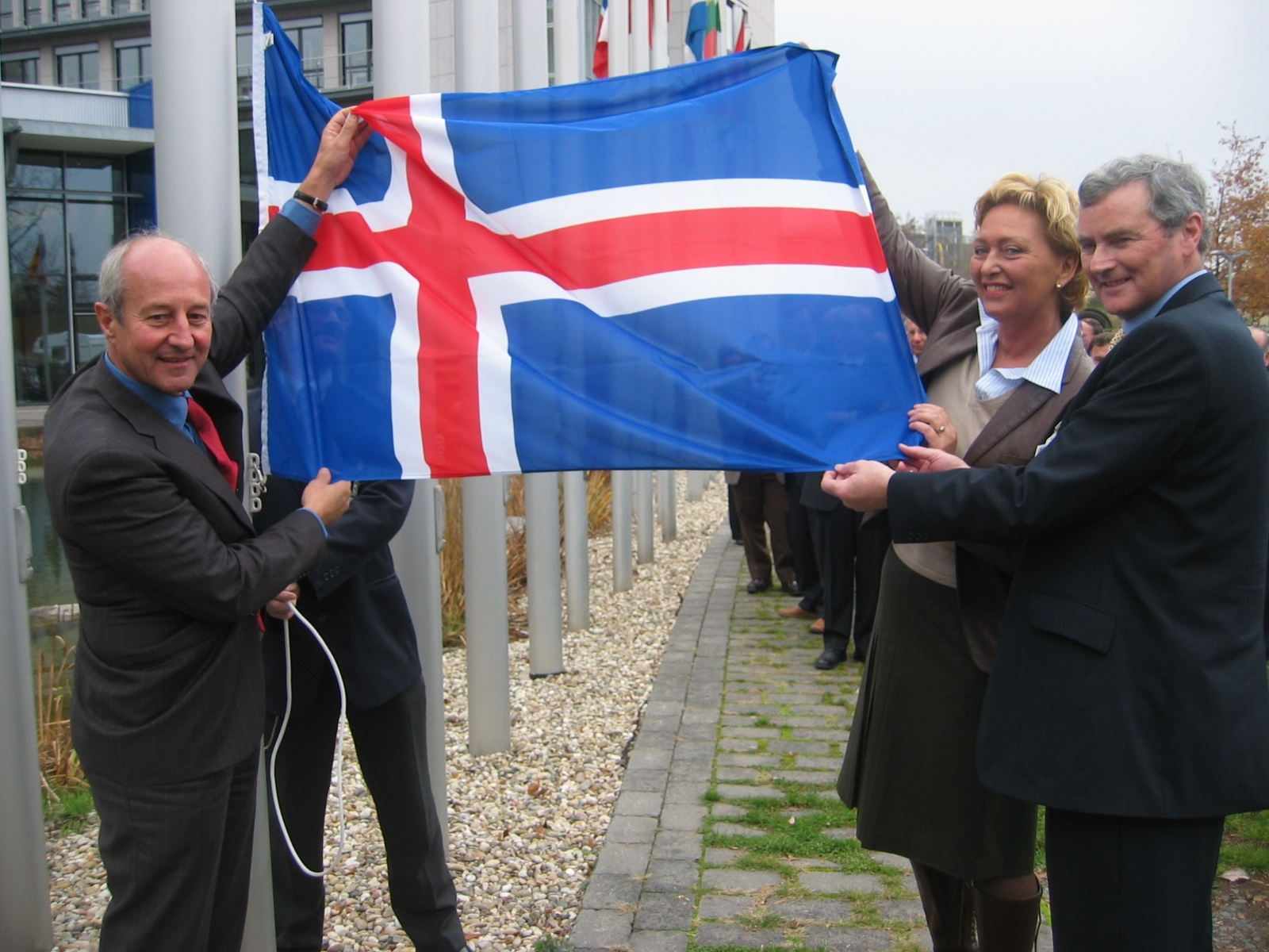 Jónína Bjartmarz umhverfisráðherra dregur íslenska fánann að húni ásamt Lars Prahm, framkvæmdastjóri EUMETSAT, og Declan Murphy, formanni stjórnar aðaldarríkja EUMETSAT.